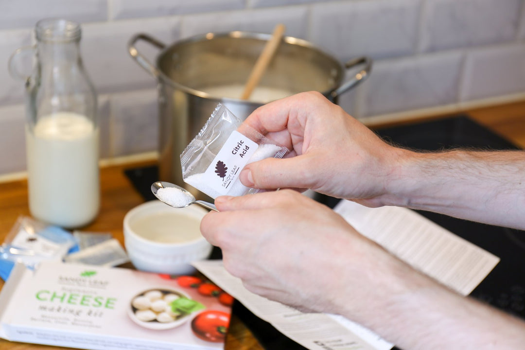 Sachet of vegetarian rennet with milk and fresh curds during home cheese making